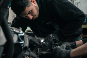 Автомобилен техник работи по двигател в сервиз